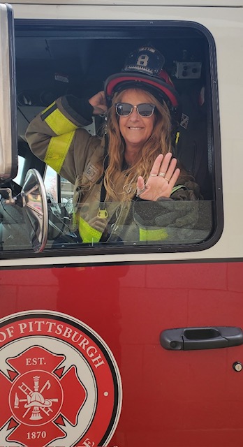 waving from a fire truck during a foundation event