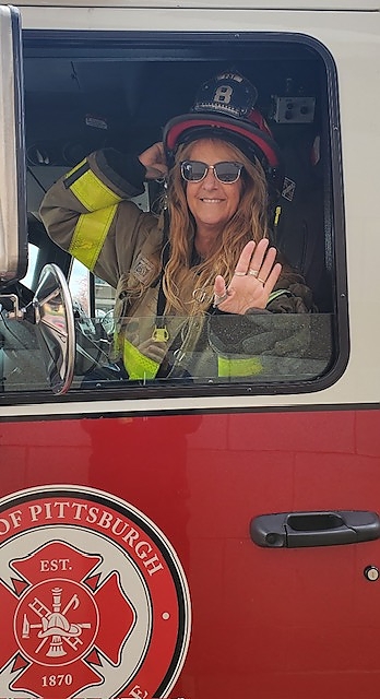waving from a fire truck during a foundation event